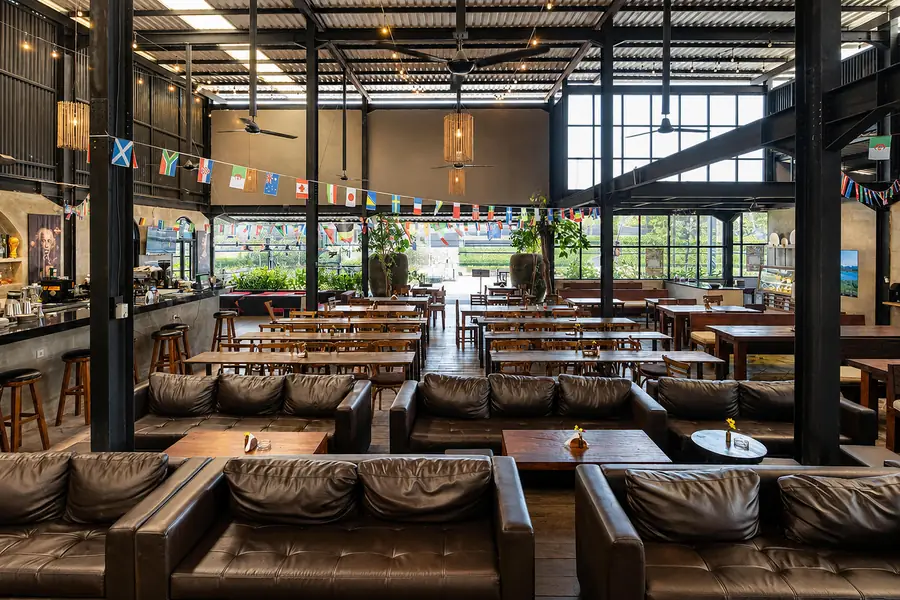 Long communal tables and leather bench seating in the main hall at Garden Canggu