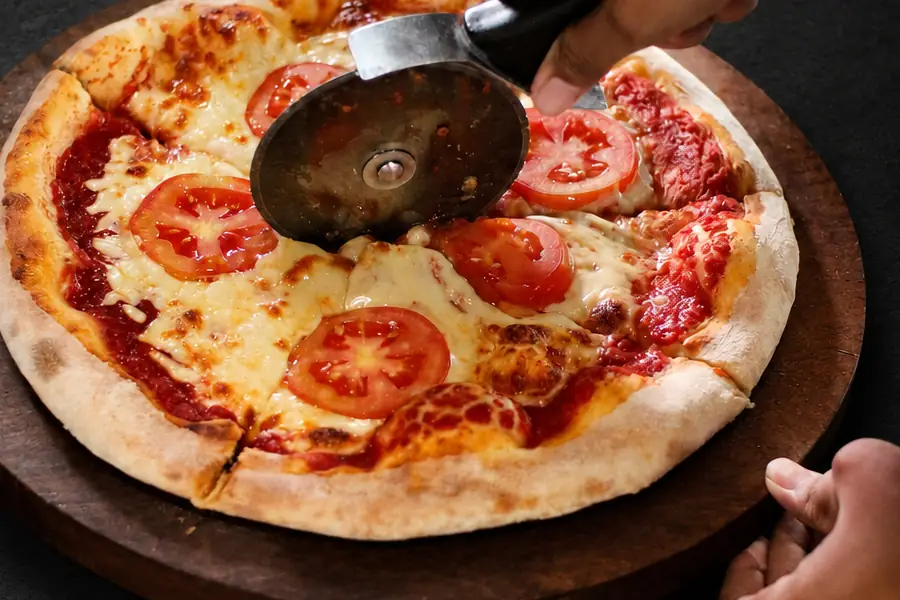 A freshly baked Garden Canggu pizza being sliced