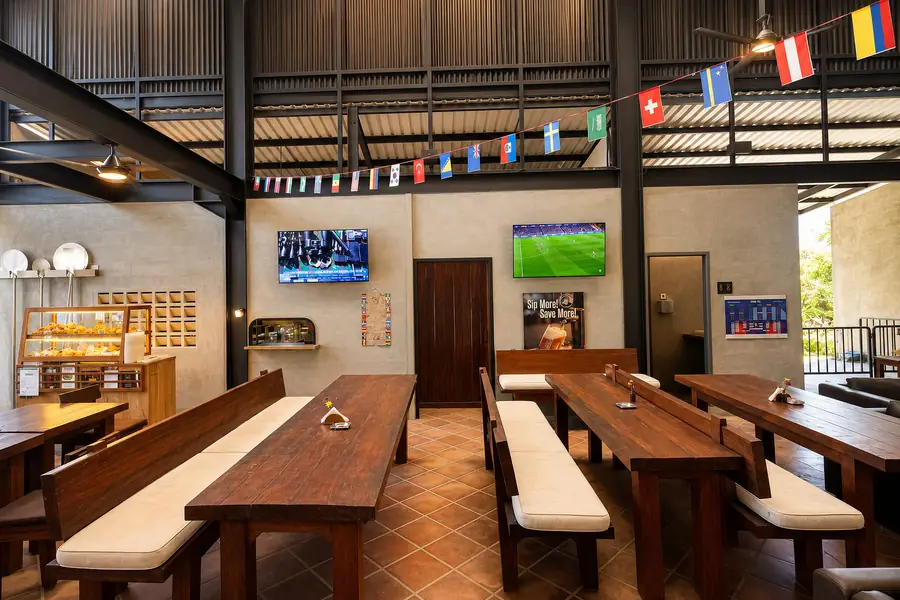 The dining room at Garden Canggu with the sports screens and standings board